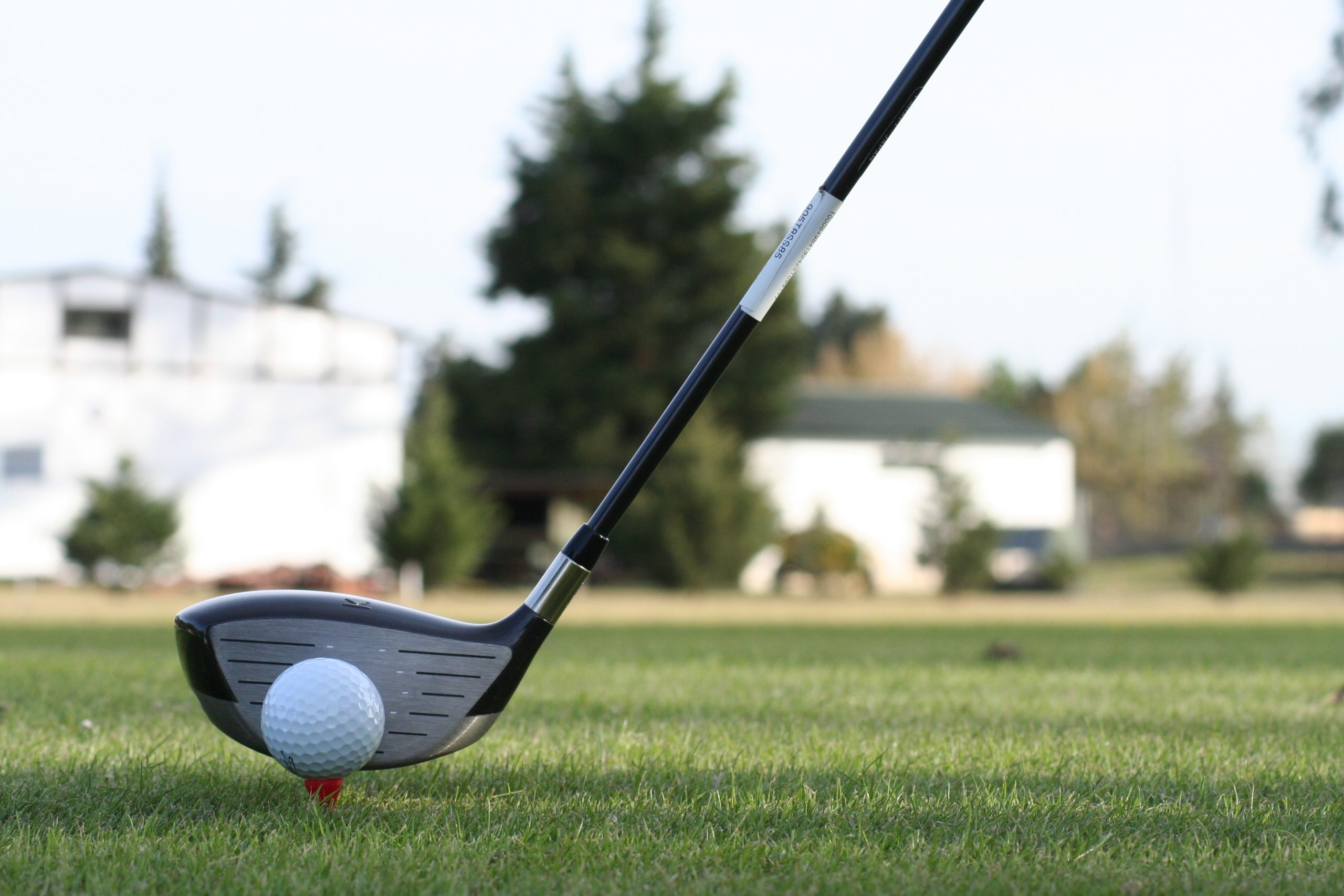 Golf club about to strike the ball